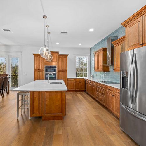 Spacious kitchen with pendant lights and stainless appliances