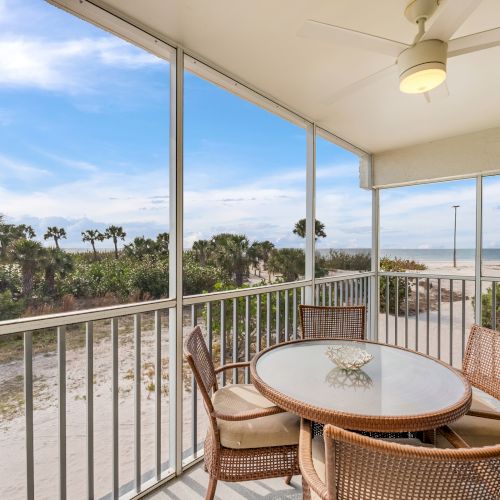 Screened balcony with round table and four chairs