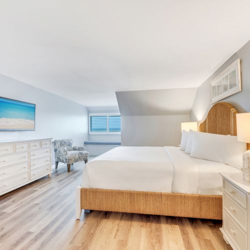 Bright bedroom with a king bed, TV, and cozy chairs