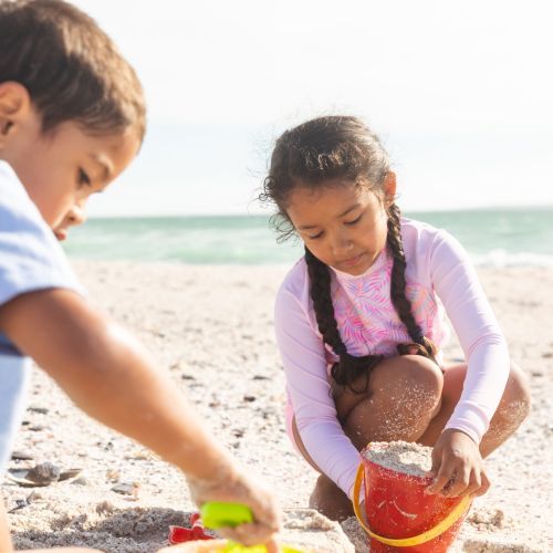 Children building sandcastles by the ocean
