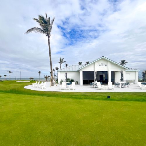 Golf clubhouse with palm trees and green lawn