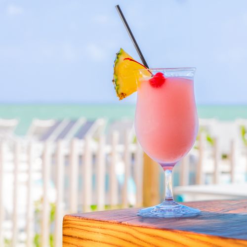 Frozen tropical cocktail with pineapple and cherry garnish