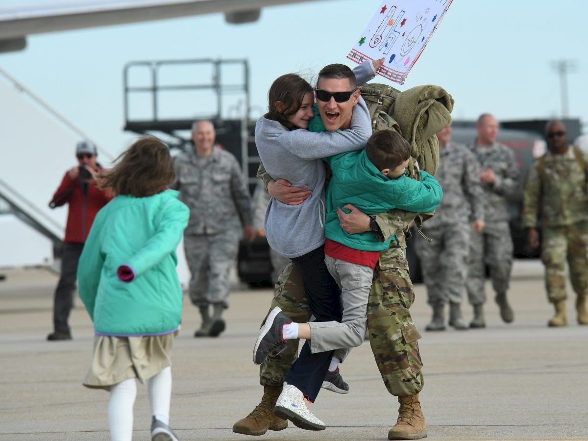 A joyful military homecoming with family hugs