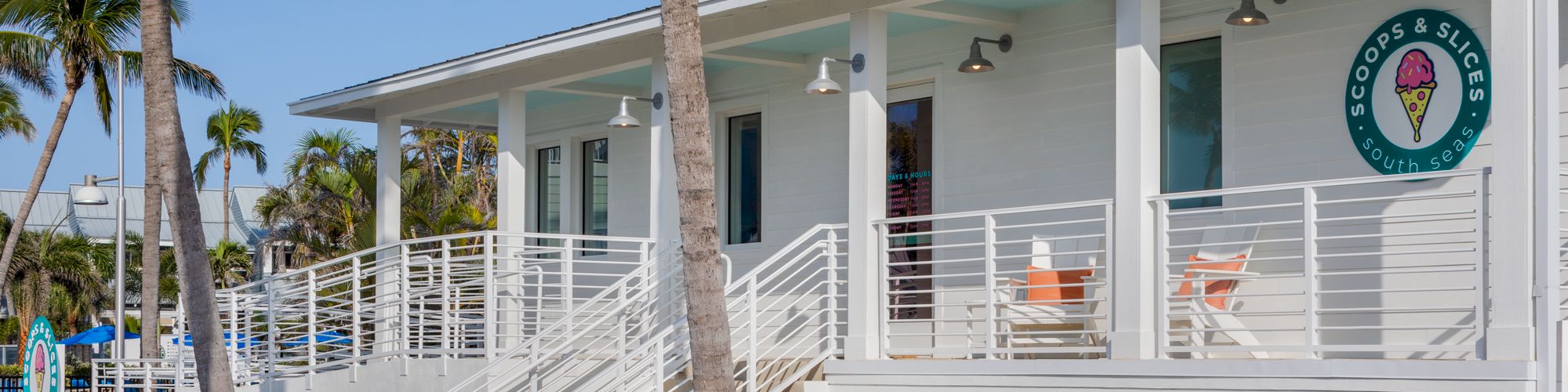 Coastal style ice cream shop with white exterior and palm trees