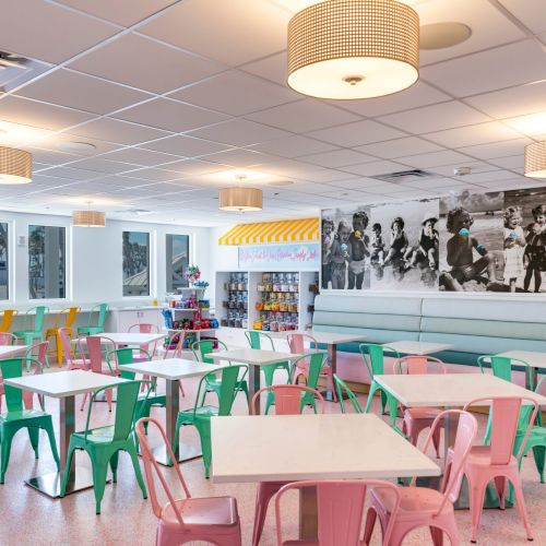 Colorful indoor seating at Scoops & Slices with pastel chairs and candy display
