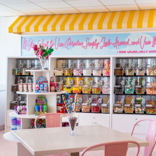 Colorful candy shop interior with jars and pink chairs