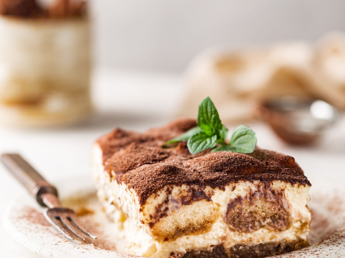 Piece of traditional Italian dessert tiramisu on white background