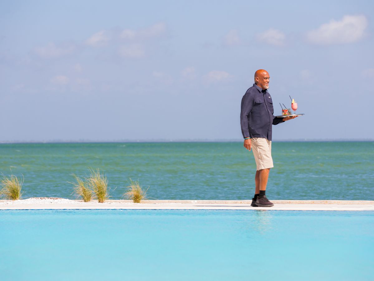 Resort staff carrying drinks by the ocean
