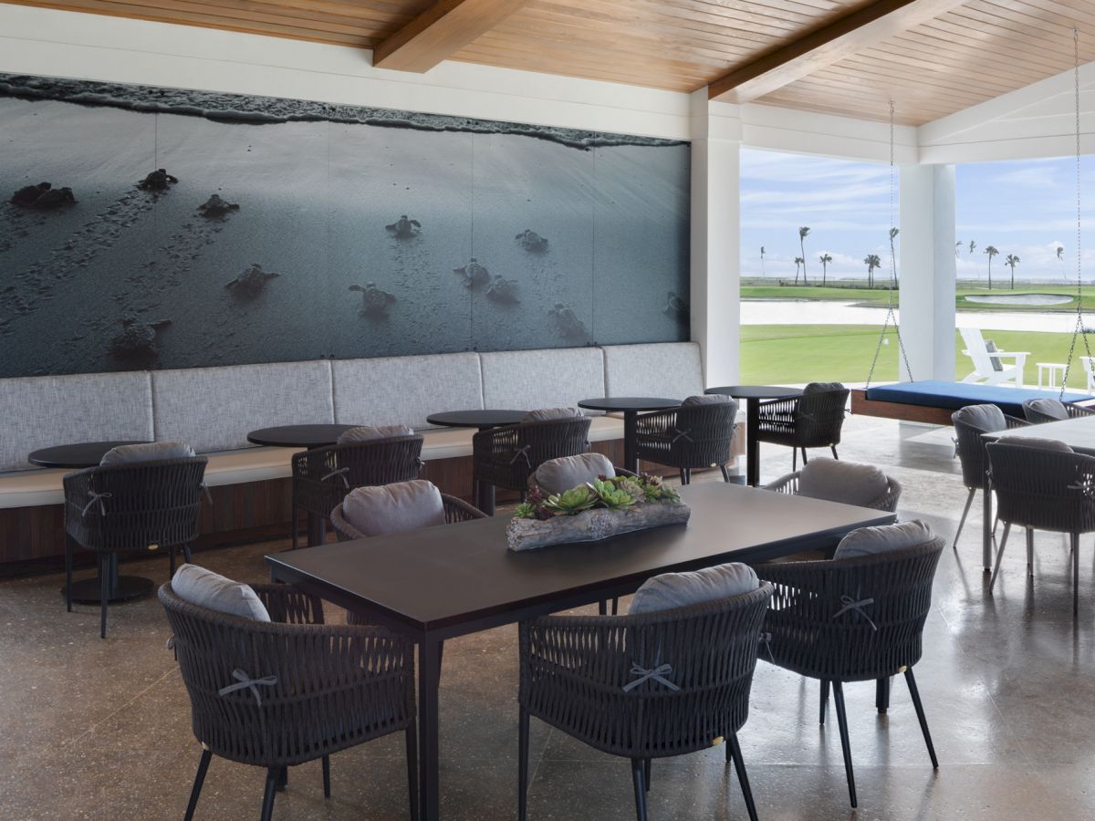 Indoor seating area with large ocean photo and golf view