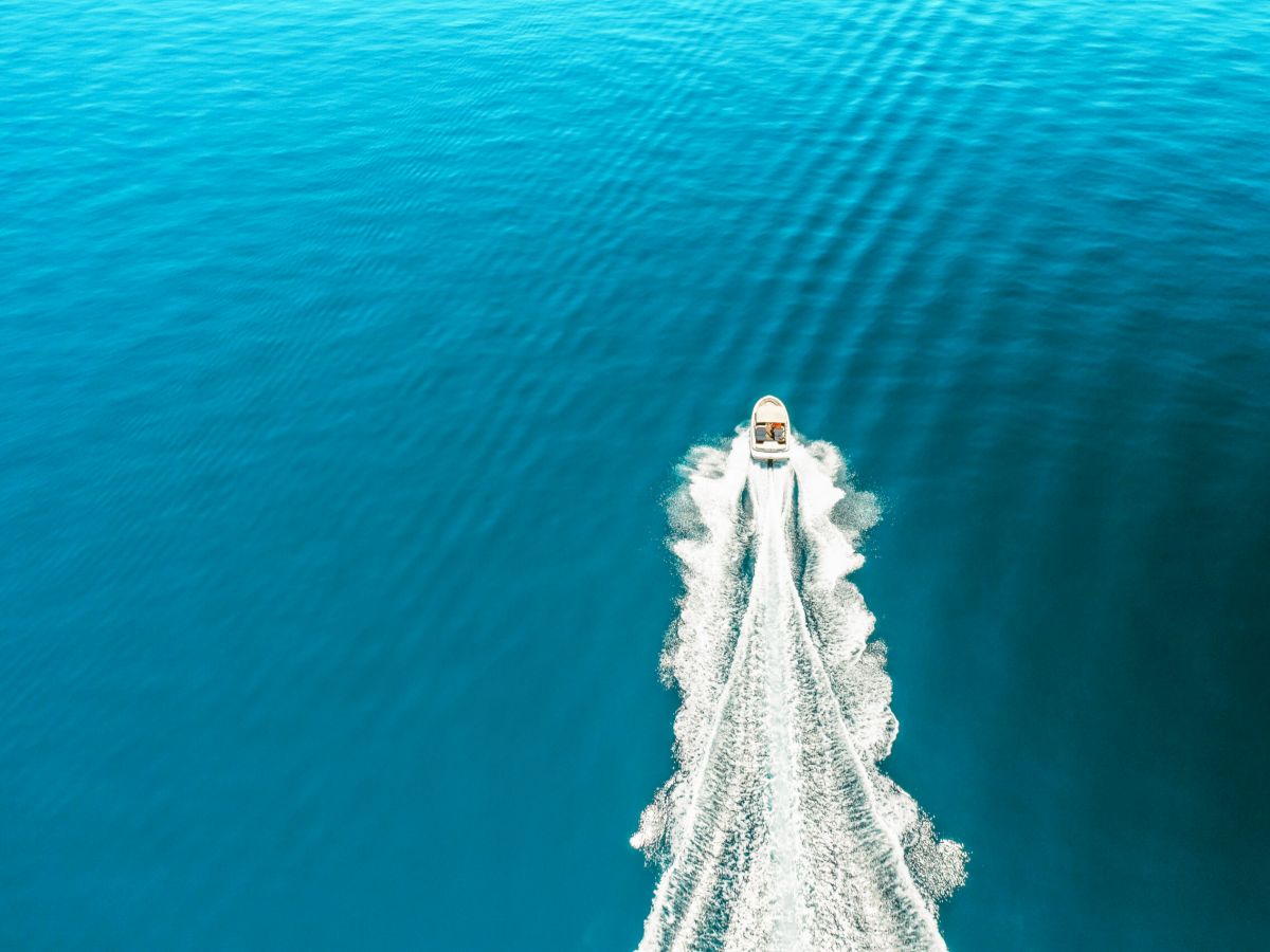 Aerial view of a boat speeding through blue water