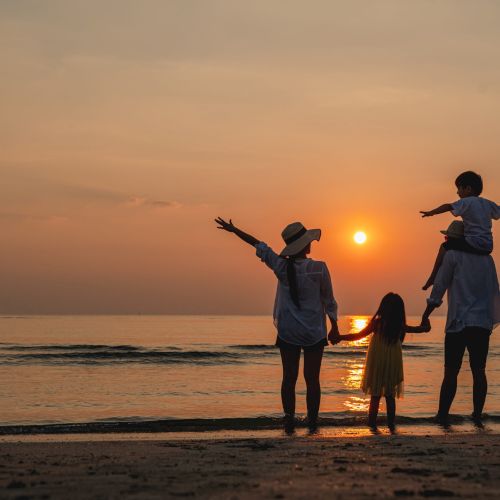 Happy asian family together on the beach in holiday. of the family holding hands enjoying the sunset on the beach.Summer,Family and vacations concept.