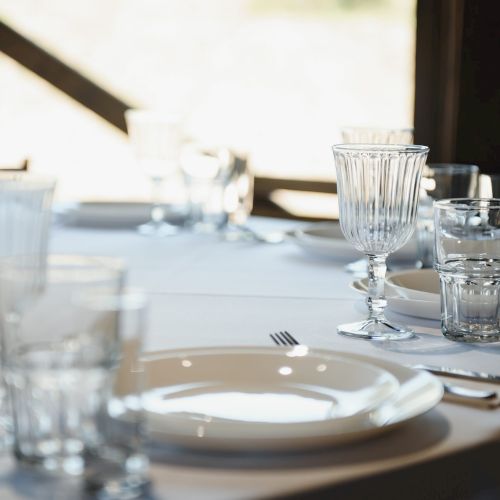 beautifully laid tables with glasses and appliances at morning in restaurant