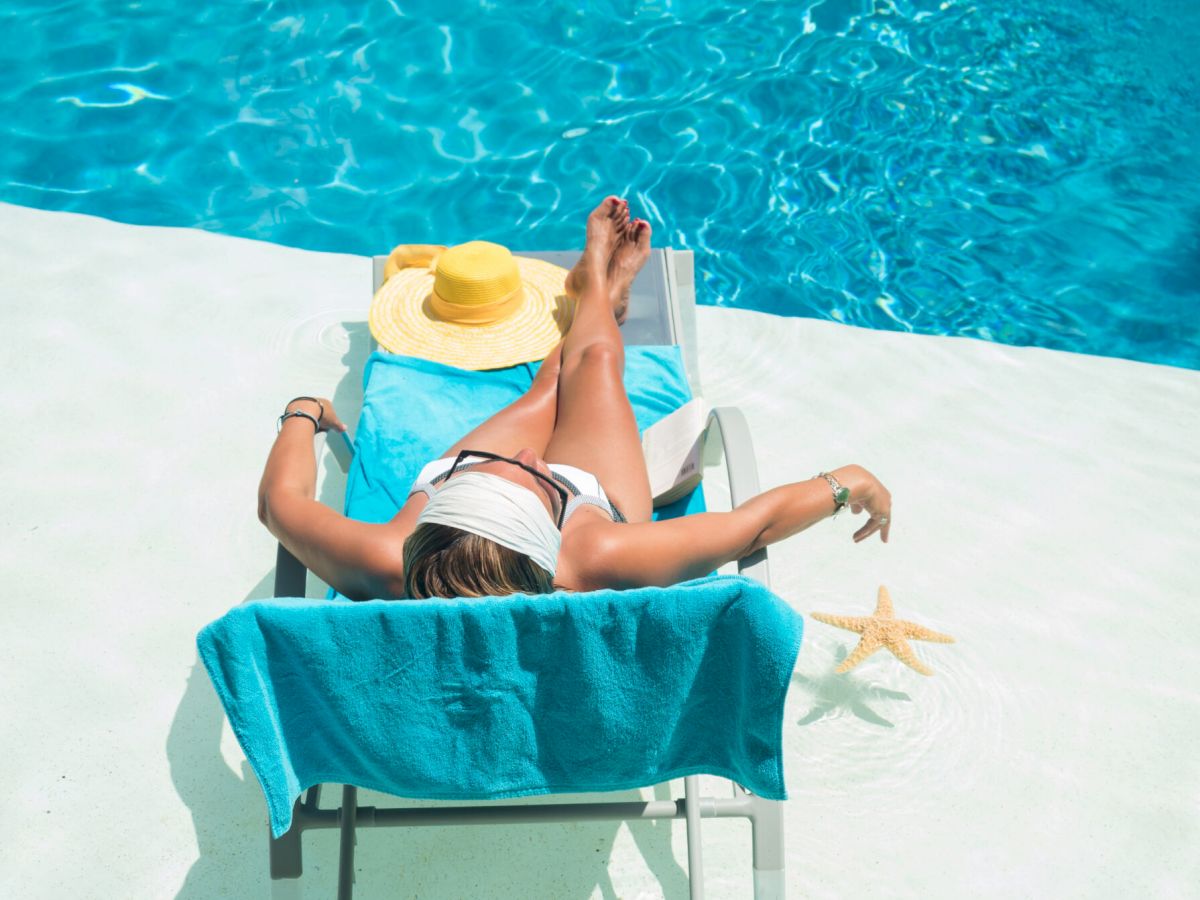 Top view of a woman sunbathing by the pool at South Seas