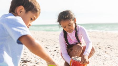 Children building sandcastles by the ocean