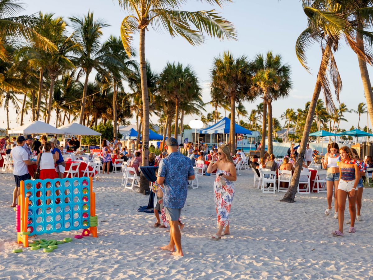 Beach event with people enjoying games and gatherings at South Seas