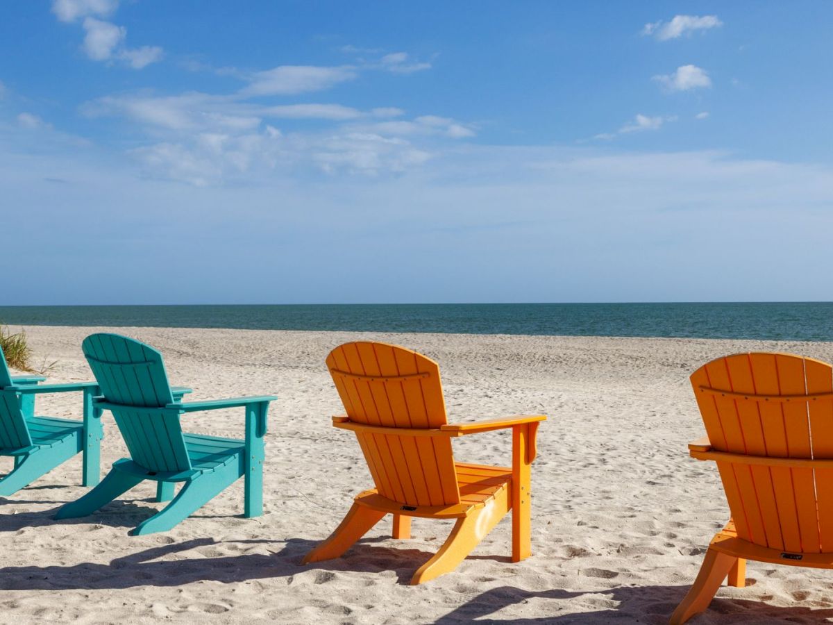 Empty colorful beach chairs facing the ocean