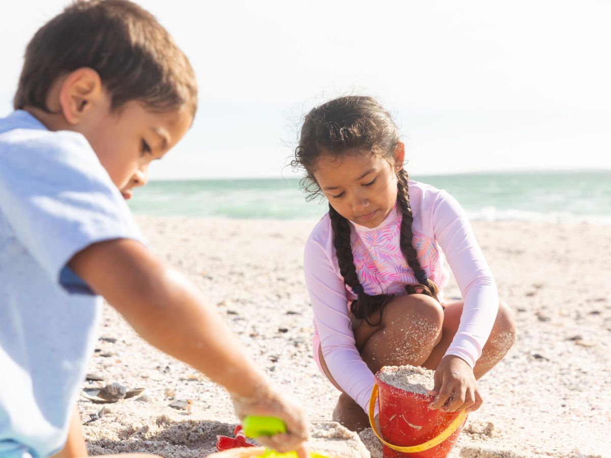 Children building sandcastles by the ocean