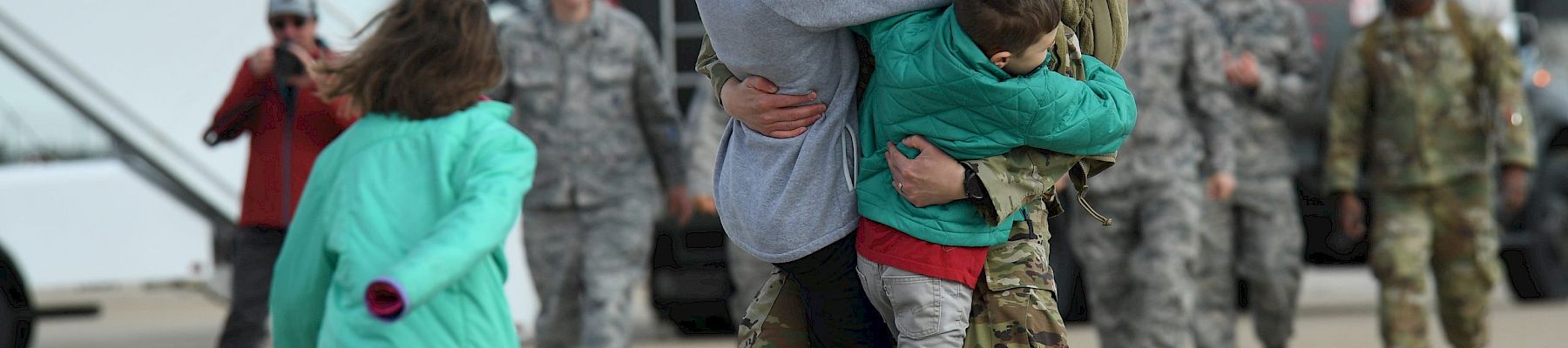 A joyful military homecoming with family hugs