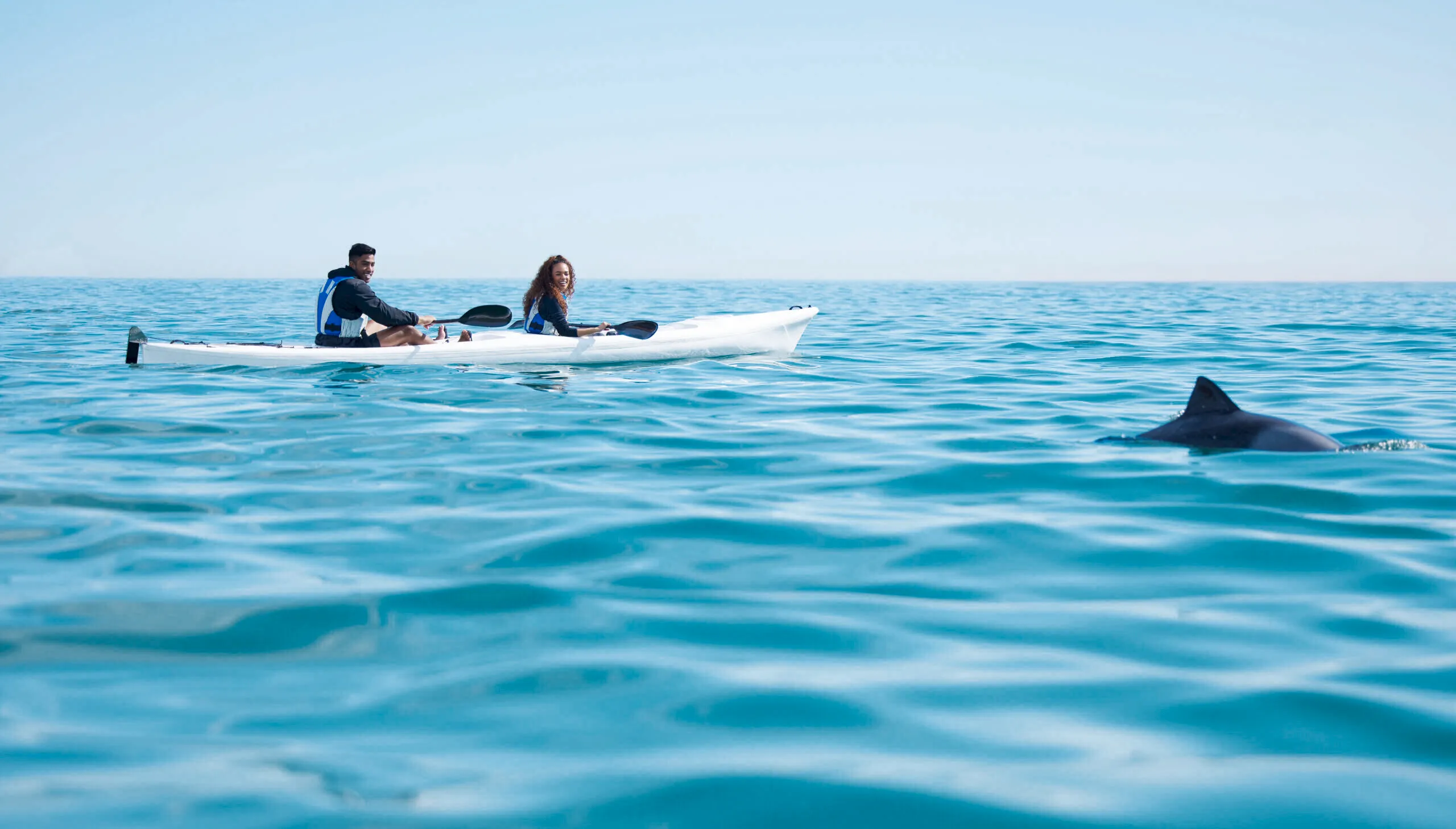 Couple kayaking on calm ocean waters at South Seas