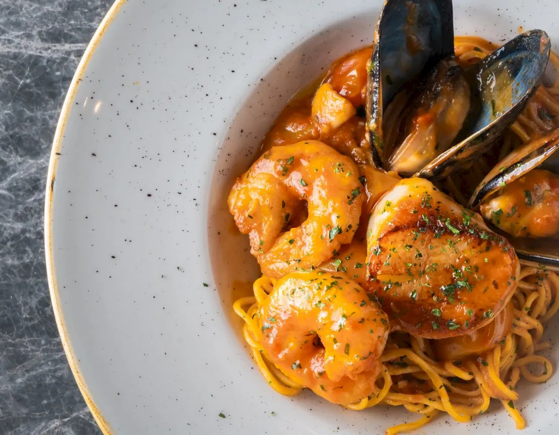 Shrimp pasta in creamy sauce served in a white bowl