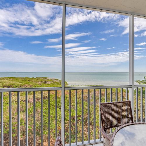 Screened balcony overlooking beach and ocean.