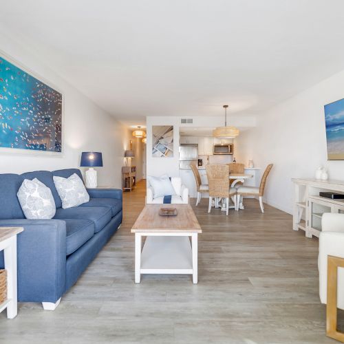 Couch, chairs, coffee table, and TV in a bright room