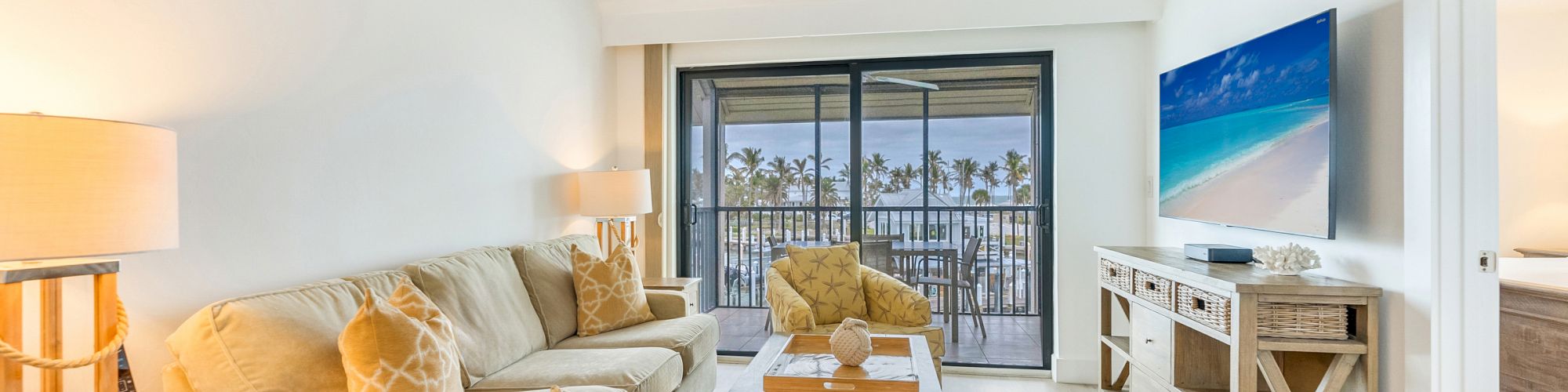 Living room with sofa chairs TV and balcony view
