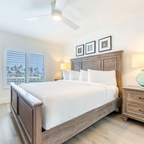 Bright bedroom with wooden bed two lamps and window view