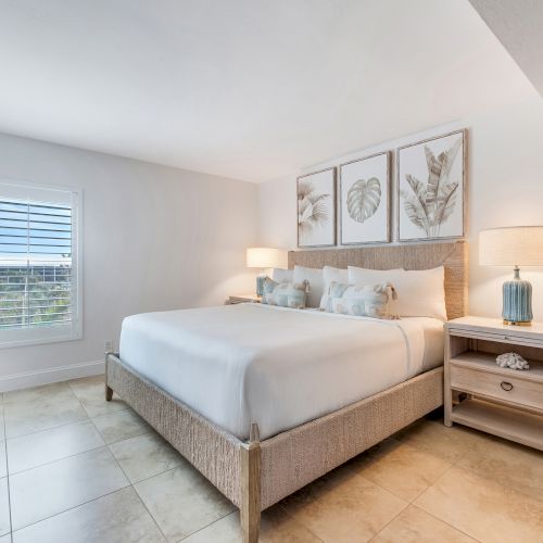 Bedroom with bed, nightstands, and framed art.