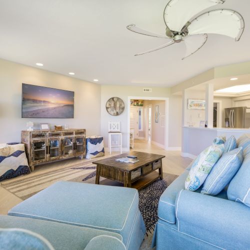 Cozy living room with blue sofa, wooden coffee table, and large ceiling fan