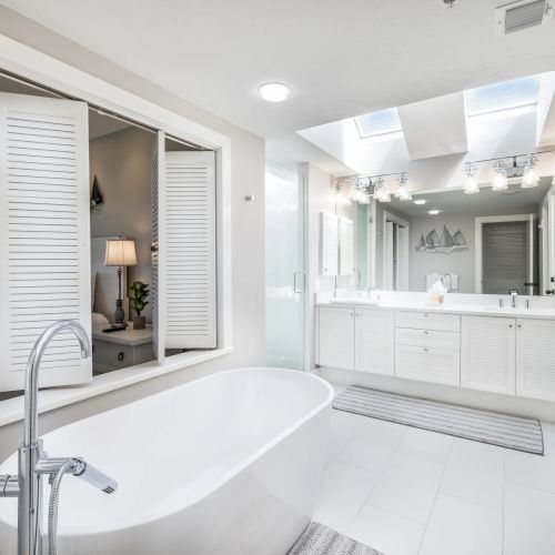 Bright bathroom with bathtub and vanity mirrors