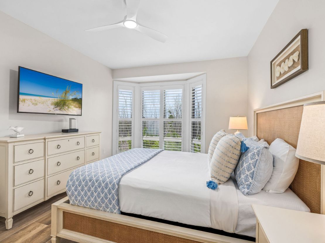 Bright and cozy bedroom with a beachy feel and a large window view