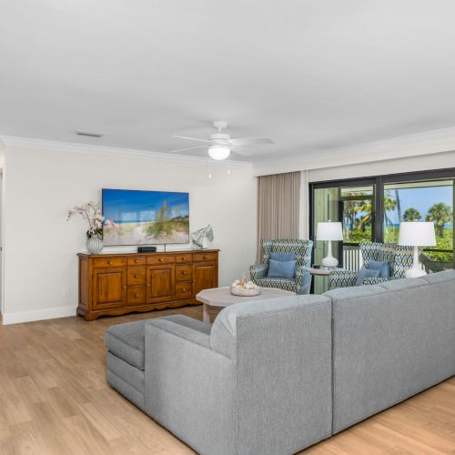 Living space with TV console, sofa, and bright windows