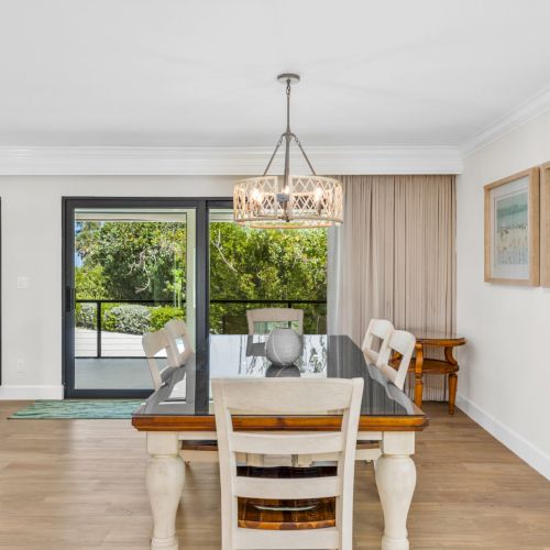 Dining area with white chairs and chandelier