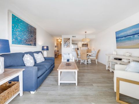 Couch, chairs, coffee table, and TV in a bright room