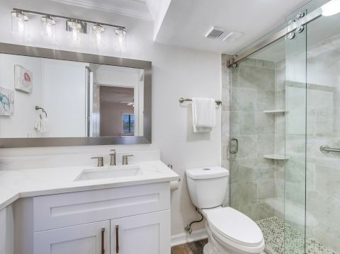 Modern bathroom with glass shower and white vanity.