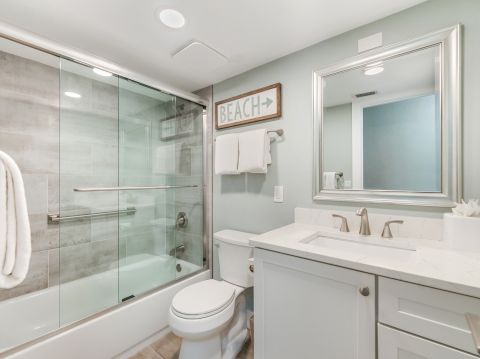 Bathroom with glass shower, toilet, and sink.