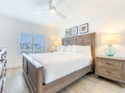 Bright bedroom with wooden bed two lamps and window view