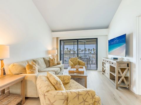 Living room with sofa chairs TV and balcony view