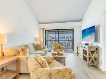 Living room with sofa chairs TV and balcony view