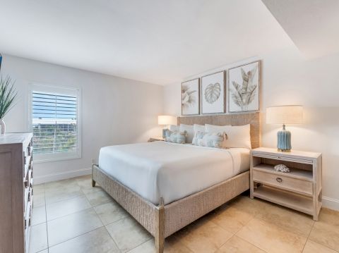 Bedroom with bed, nightstands, and framed art.