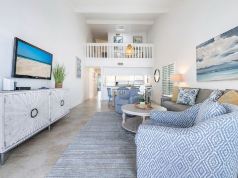 Sofa and TV in the living room, and the kitchen behind it