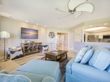 Cozy living room with blue sofa, wooden coffee table, and large ceiling fan