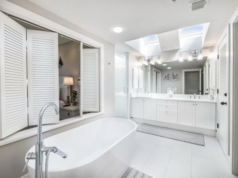 Bright bathroom with bathtub and vanity mirrors