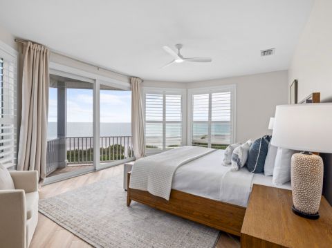 Bedroom with ocean view and white bed
