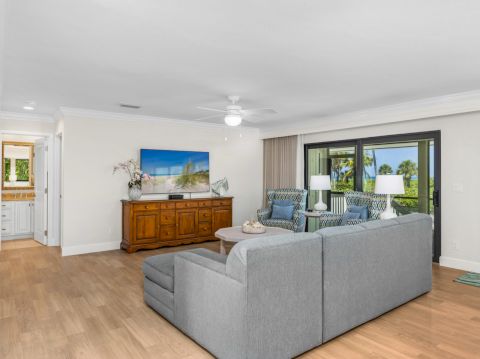 Living space with TV console, sofa, and bright windows