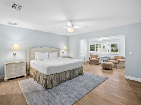 Bedroom with king bed, blue walls, and sitting area