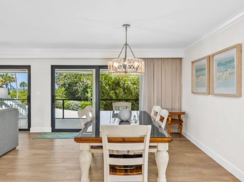 Dining area with white chairs and chandelier