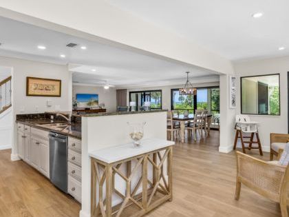 Open-concept space with kitchen, wooden floors, and dining area with large windows